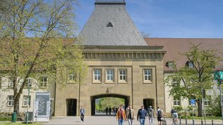 Studenten vor dem Haupteingang am Tor-Gebäude der Johannes Gutenberg-Universität Mainz in Rheinland-Pfalz.