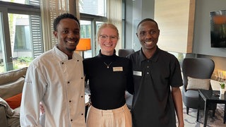 Christian und Jean Jacques stehen im  Mainzer Atrium Hotel neben Hannah Manz aus der Personalabteilung des Hotels