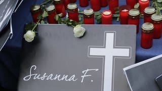 Kerzen liegen vor einem gebastelten Grabstein für die getötete Susanna F.