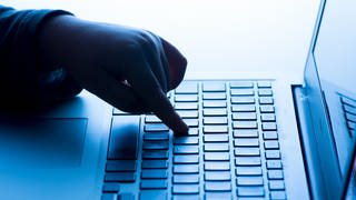 Hackerangriff bei den Mainzer Stadtwerken: Eine Hand tippt auf einer Laptop-Tastatur.
