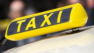 Ein gelbes Taxischild auf einem Autodach