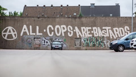 An einer Wand steht der Schriftzug "All cops are bastards", mit dem Polizisten beleidigt werden