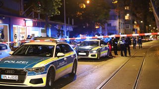 Vor einer Sportsbar in der Mainzer Neuustadt stehen mehrere Polizeiautos, ein Teil der Staraße wurde mit Flatterband abgesperrt. 