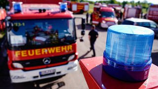 Feuerwehrfahrzeuge stehen auf einem Parkplatz bei einer Katastrophenschutzübung im Soonwald. 