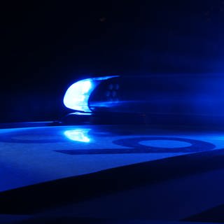 Polizei-Blaulicht an Auto im Dunkeln.