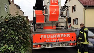 Ein Feuerwehrauto kommt bei einem Einsatz in der Verbandsgemeinde Nieder-Olm nicht weiter, weil es zwischen einer Mauer und einem parkenden Auto zu eng ist. 