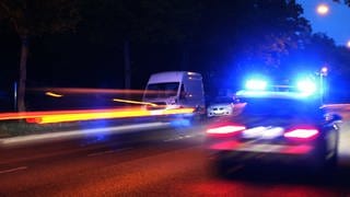 Ein Einsatzfahrzeug der Mainzer Polizei ist nachts mit Blaulicht unterwegs.