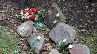 Blumen auf Gedenksteinen für die Opfer in Auschwitz. Denen wird am 27. Januar auch in bad Kreuznach, Mainz und Worms gedacht.