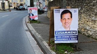 Wahlplakate von Christian Viering und Nino Haase stehen an der Hauptstraße in Mainz-Finthen