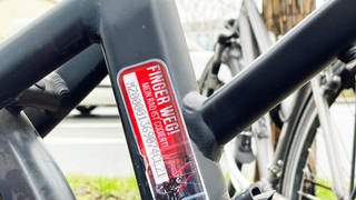 Auf einem codierten Fahrrad wurde ein Aufkleber angebracht, auf dem eine Nummer eingestanzt wurde. Zu lesen ist zudem die Sätze: "Finger weg! Mein Rad ist codiert!"