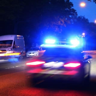 Die Polizei fährt nachts mit einem Einsatzfahrzeug durch Mainz. 