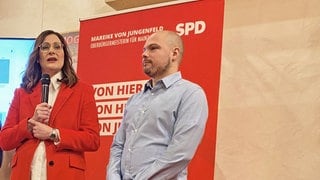 Die Vorsitzende der SPD-Stadtratsfraktion Jana Schmöller und die beiden Vorsitzenden, Mareike von Jungenfeld und Christian Kanka, stehen auf einem roten Teppich. Im Hintergrund steht eine Wand mit SPD-Logos.