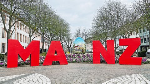 Am Fastnachtsbrunnen wird ein Ei von den Buchstaben M, A, N und Z eingerahmt. Das I fehlt, dafür steht dort ein kroatisches Ei. Die Buchstaben sind Teile Teil einer Marketingkampagne. 