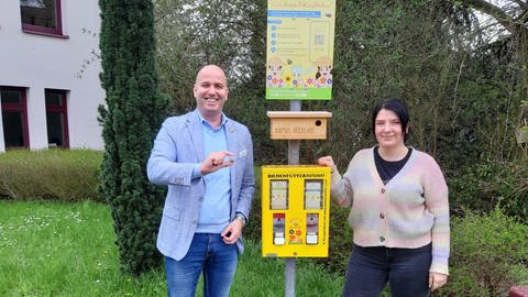Der Bienenfutterautomat steht zwischen VG Bügermeister Cyfka und der VG-Klimaschutzmanagerin Recker.