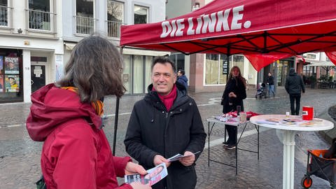 Martin Malcherek vor seinem Wahlkampf-Stand auf dem Mainzer Schillerplatz im Gespräch mit einer Mainzer Bürgerin.