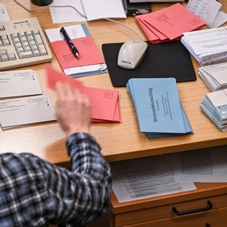 In einem Briefwahlbüro werden die eingereichten Unterlagen sortiert.