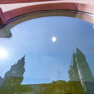 Der Mainzer Dom spiegelt sich in einer Schaufensterscheibe am Marktplatz.
