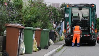 Ein Müllarbeiter der Abfallentsorgung leert die Hausmülltonnen.