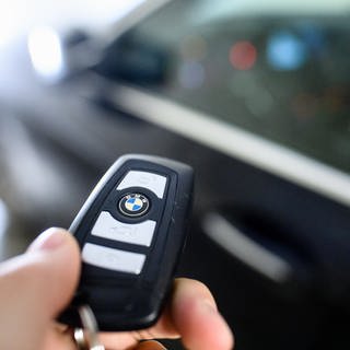 Eine Hand hält einen Funk-Schlüssel mit Keyless-Go-System.