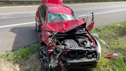 Ein zerstörtes rotes Auto steht nach einem Unfall an der Autobahn A643 bei Mainz-Gonsenheim