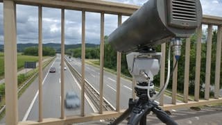 Eine Verkehrsüberwachungskamera steht auf einer Autobahnbrücke