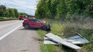 Ein kaputtes rotes Auto steht nach einem Unfall am Rand der Autobahn A643 bei Mainz-Gonsenheim