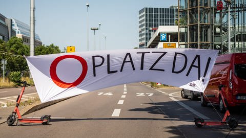 Platz da!» steht auf einem Banner an der Bundesstraße B14 geschrieben. Das Bild stammt aus Stuttgart, dort hatten Bündnisse zu einem Picknick und Beisammensein auf einer gesperrten Bundesstraße eingeladen.