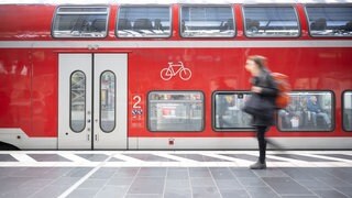 Eine Frau geht am Frankfurter Hauptbahnhof an einer Regionalbahn vorbei.