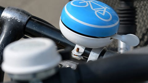 An einem Fahrradlenker ist eine Fahrradklingel mit Fahrradsymbol befestigt. Bei einer Rad-Demo in Mainz wird am Donnerstag eine Spur der Alicenbrücke für Autos gesperrt.