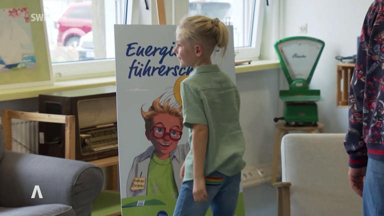 Grundschulkind vor Plakat "Energiesparführerschein"