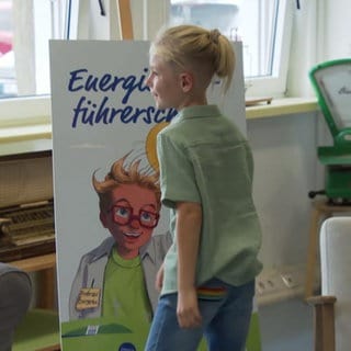 Grundschulkind vor Plakat "Energiesparführerschein"