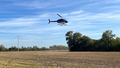 EWR überprüft Strommasten bei Worms mit Hubschrauber.