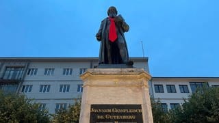 Die Gutenberg-Statue in Mainz trägt jetzt eine leuchtend rote Krawatte.