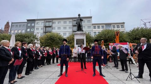 In einer feierlichen Zeremonie wird der Gutenberg-Statue die Krawatte umgehängt.