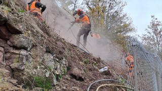 Nach dem Erdrutsch an der Bahnstrecke in Schloßböckelheim sichern Bauarbeiter den Hang.