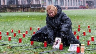 Die Mutter der bei der Flut verstorbenen Johanna stellt ein Foto ihrer Tochter bei der Mahnwache auf