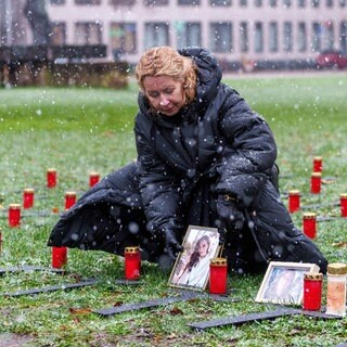 Die Mutter der bei der Flut verstorbenen Johanna stellt ein Foto ihrer Tochter bei der Mahnwache auf