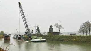 Im Witerhafen in Mainz liegt ein Frachter, auf dem der Schlamm geladen wird, der aus dem Winterhafen gebaggert wird. Auch diese Arbeiten werden von einem Schiff aus erledigt. Der Schlamm wird nach Wesel in Nordrhein-Westfalen gebracht. 