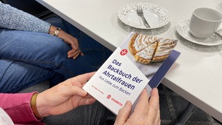 Bachbuch der Ahrtal Frauen, Omas halten Backbuch in der Hand, Backen mit Oma, Omas Backrezepte, Kuchen