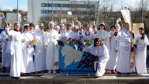 Die Frauen von Maria 2.0 stehen als Päpstinnen verkleidet beim Fastnachts-Umzug in Nieder-Olm.