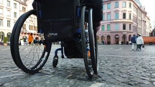 Eine Frau fährt mit dem Rollstuhl durch Mainz.