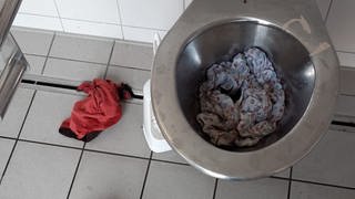 Eine Toilette ist mit Kleidung voll gestopft: Unbekannte verstopfen in Alzey immer wiederToiletten mit alten Klamotten