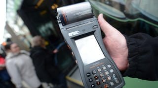 Ein Kontrolleur in Mainz hält ein Fahrscheingerät in der Hand und kontrolliert mögliche Schwarzfahrer.