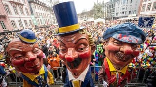 Mainzer Schwellköpp stehen zum Auftakt zur Mainzer Fastnacht auf dem Schillerplatz vor den Feierenden.