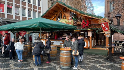 Menschen stehen vor einem Glühweinstand auf dem Wormser Weihnachtsmarkt.