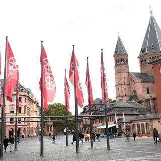 Fahnen mit dem Mainzer Rad wehen in Mainz auf dem Marktplatz vor dem Dom.