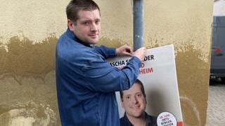 Der junge Bretzenheimer Sascha Schneider hängt sein eigenes Wahlplakat in Bretzenheim auf.