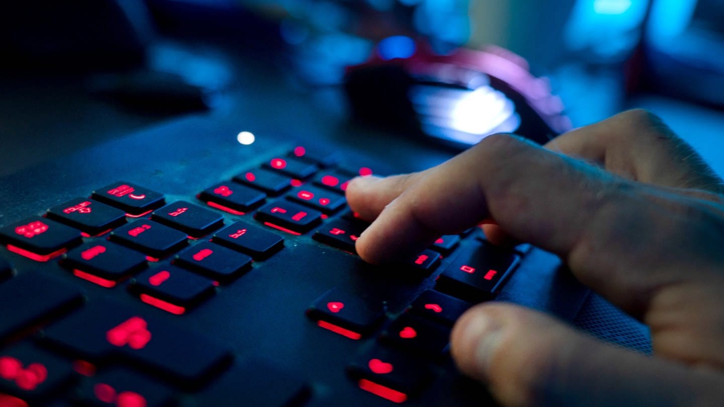 Ein Mann sitzt am Rechner und tippt auf einer Tastatur. In Mainz wurde ein Mann von seiner Internetbekannschaft erpresst. Der Mann hat Anzeige bei der Polizei erstattet.
