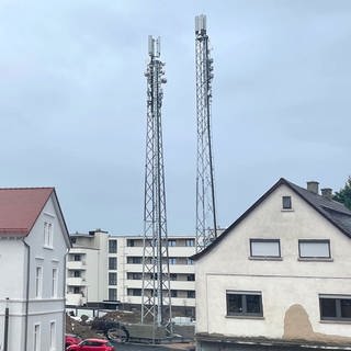 Die neuen Mobilfunkantennen (Masten rechts) in Osthofen funktionieren noch nicht, die alten (links auf dem Schillturm) sind bereits außer Betrieb. Die Gemeinde ist daher seit März vom Mobilfunk abgeschnitten und zu einem großen Funkloch geworden.
