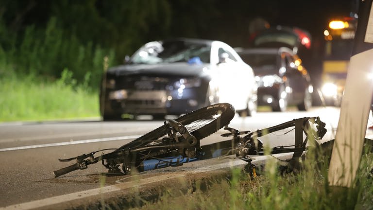 Das Auto und das Rad am Straßenrand liegend: Bei einem Unfall auf der L409 bei Alzey ist ein Radfahrer gestorben